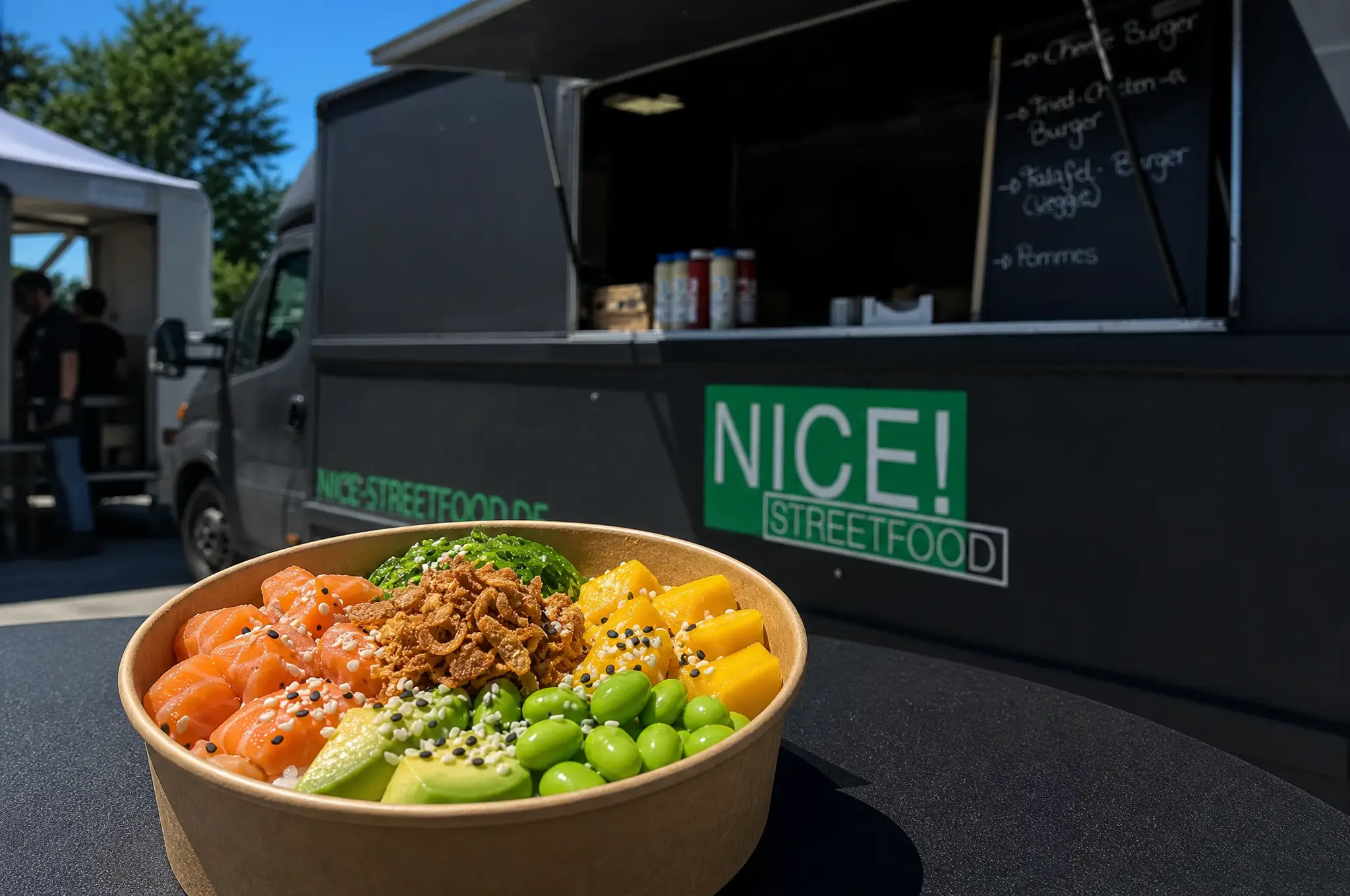 Bowl mit Lachs, Mango, Edamame und Avocado vor dem schwarzen NICE! Streetfood Truck